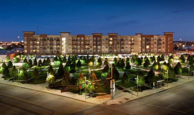 Settle into comfort at Ambrose a large building with a courtyard and trees in front of it