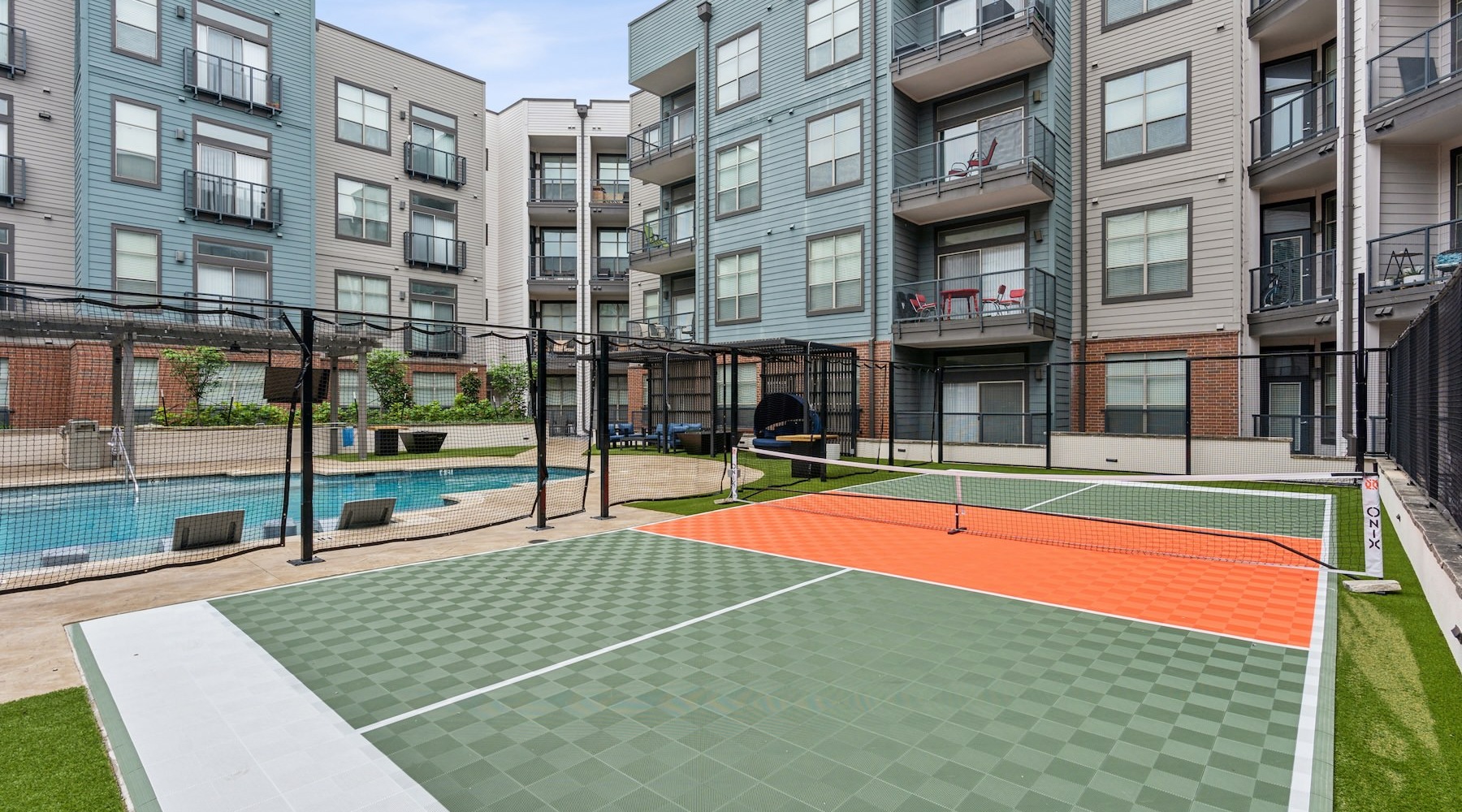 Everything within reach a tennis court next to a pool in a courtyard