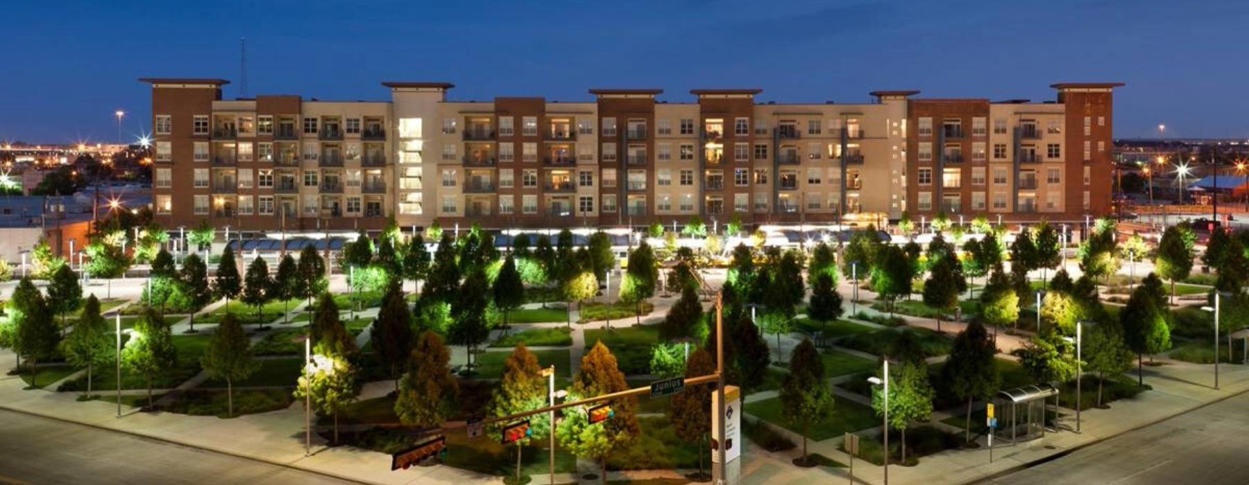 a large building with a courtyard and trees in front of it